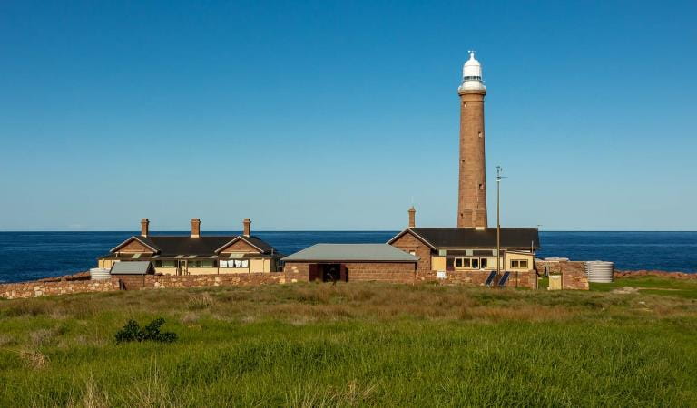 Historic Gabo Island Lighthouse rising above rugged coastline, Victoria's premier lighthouse tour destination